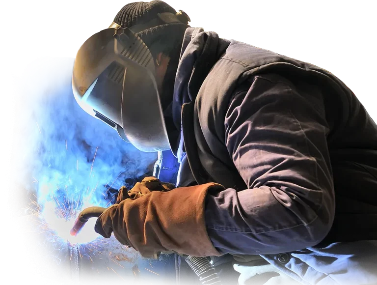 Welder in helmet welding metal