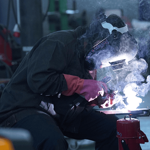 Welder welding metal in a workshop