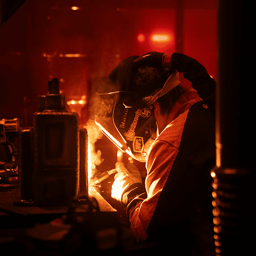 Welder working in a dark workshop